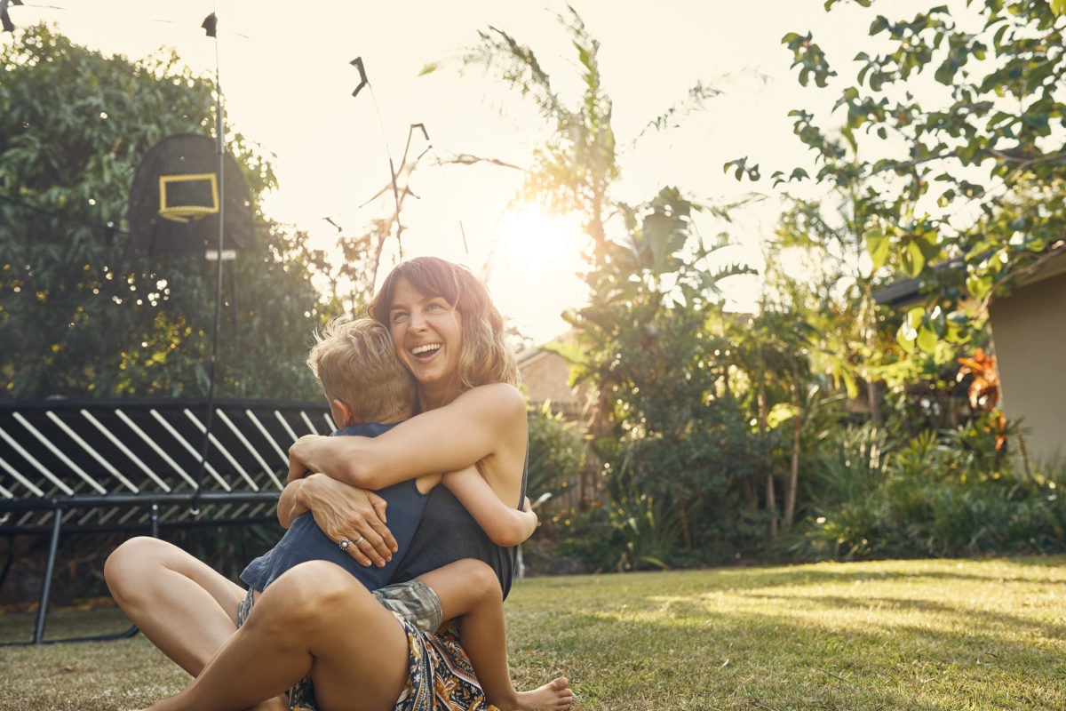 Mother snd son hugging in garden