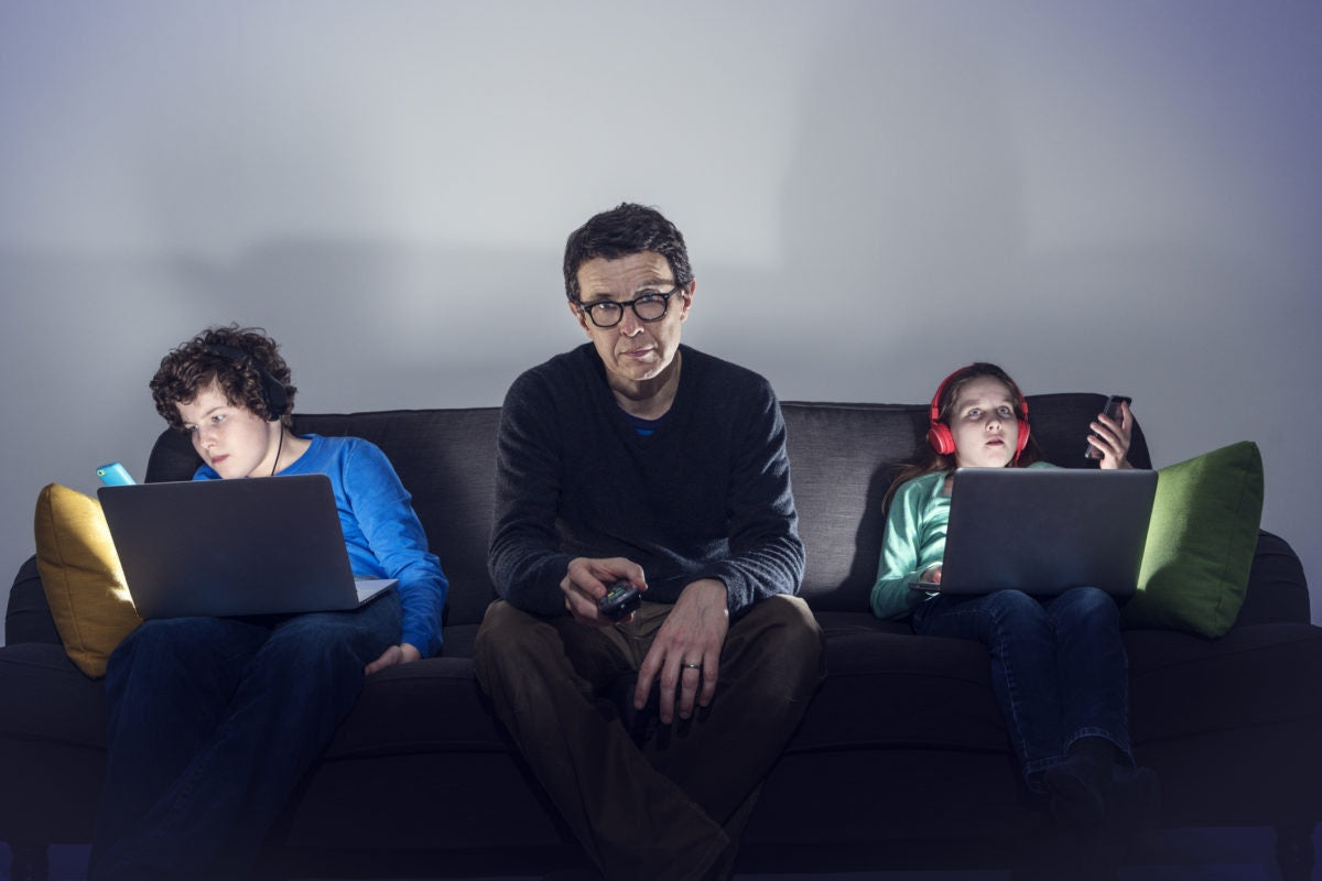 Childrens using laptop and father is watching