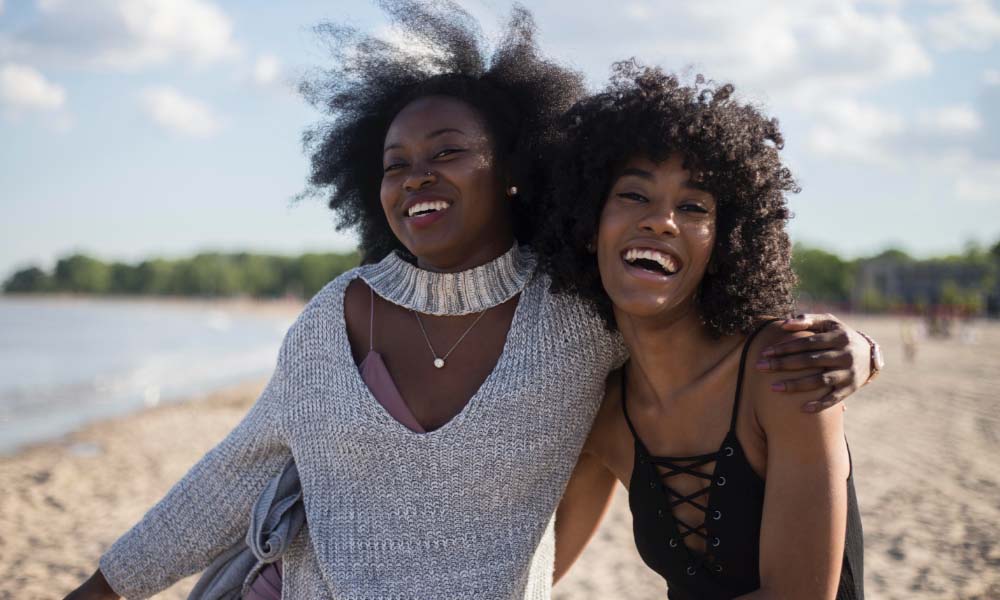 zwei lächelnde Frauen am Strand