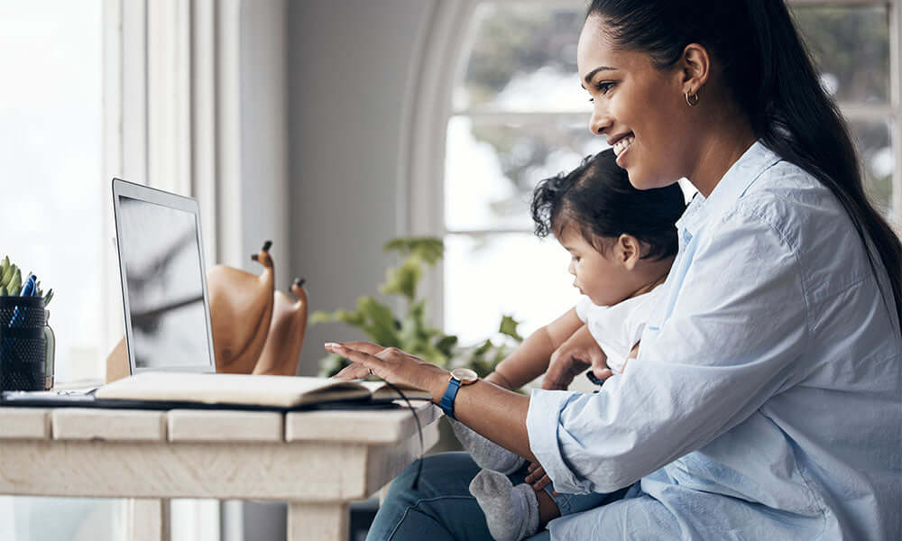 mother caring for her baby girl while working from home