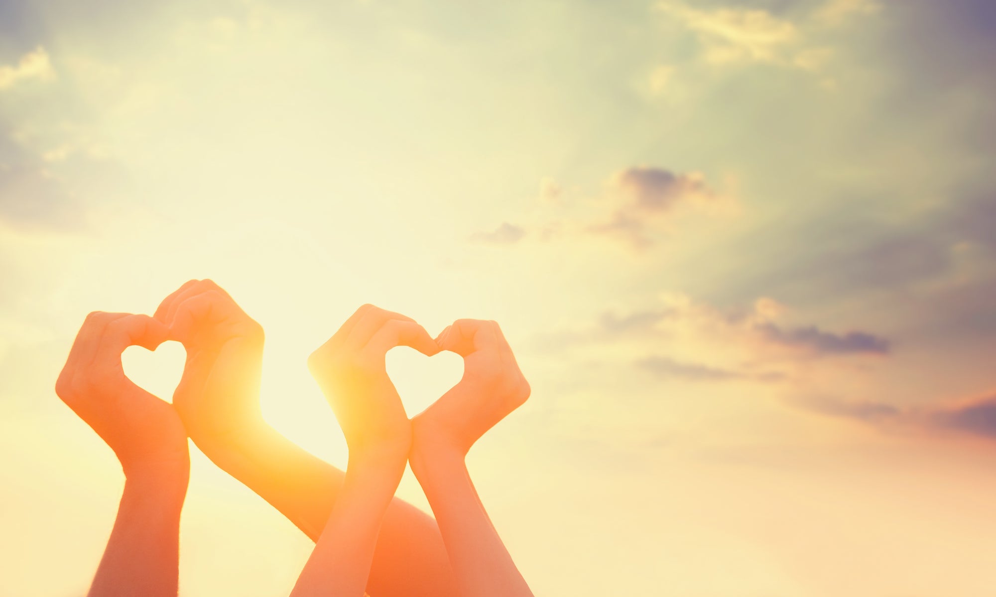 two people making heart symbol with their hands