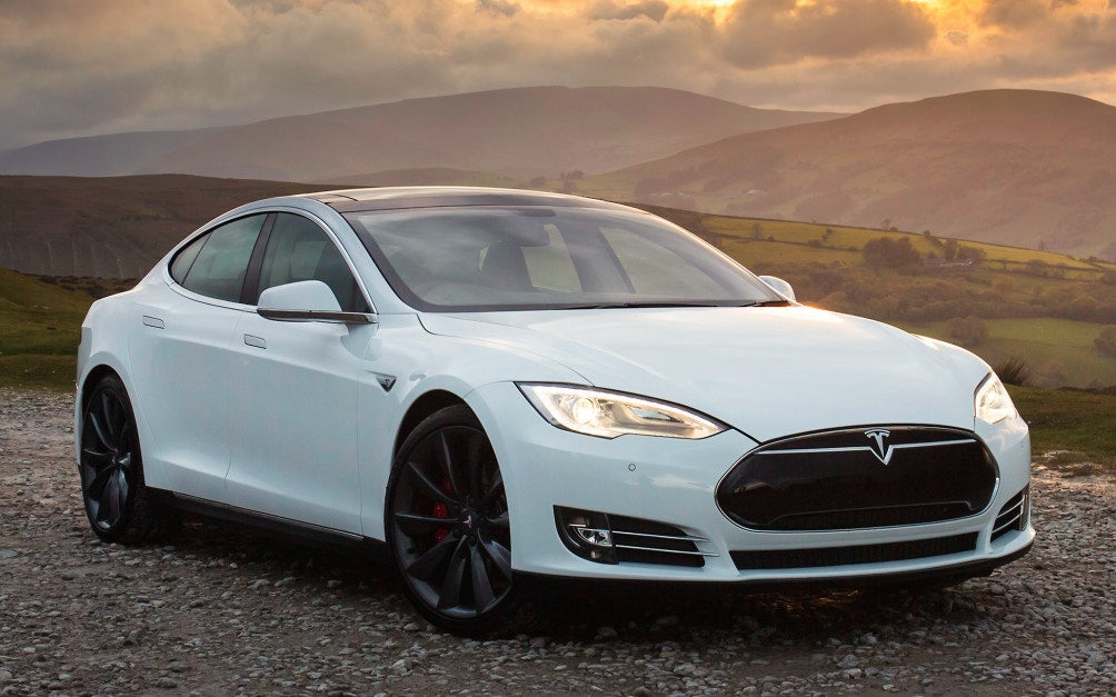 white tesla with mountains in the background