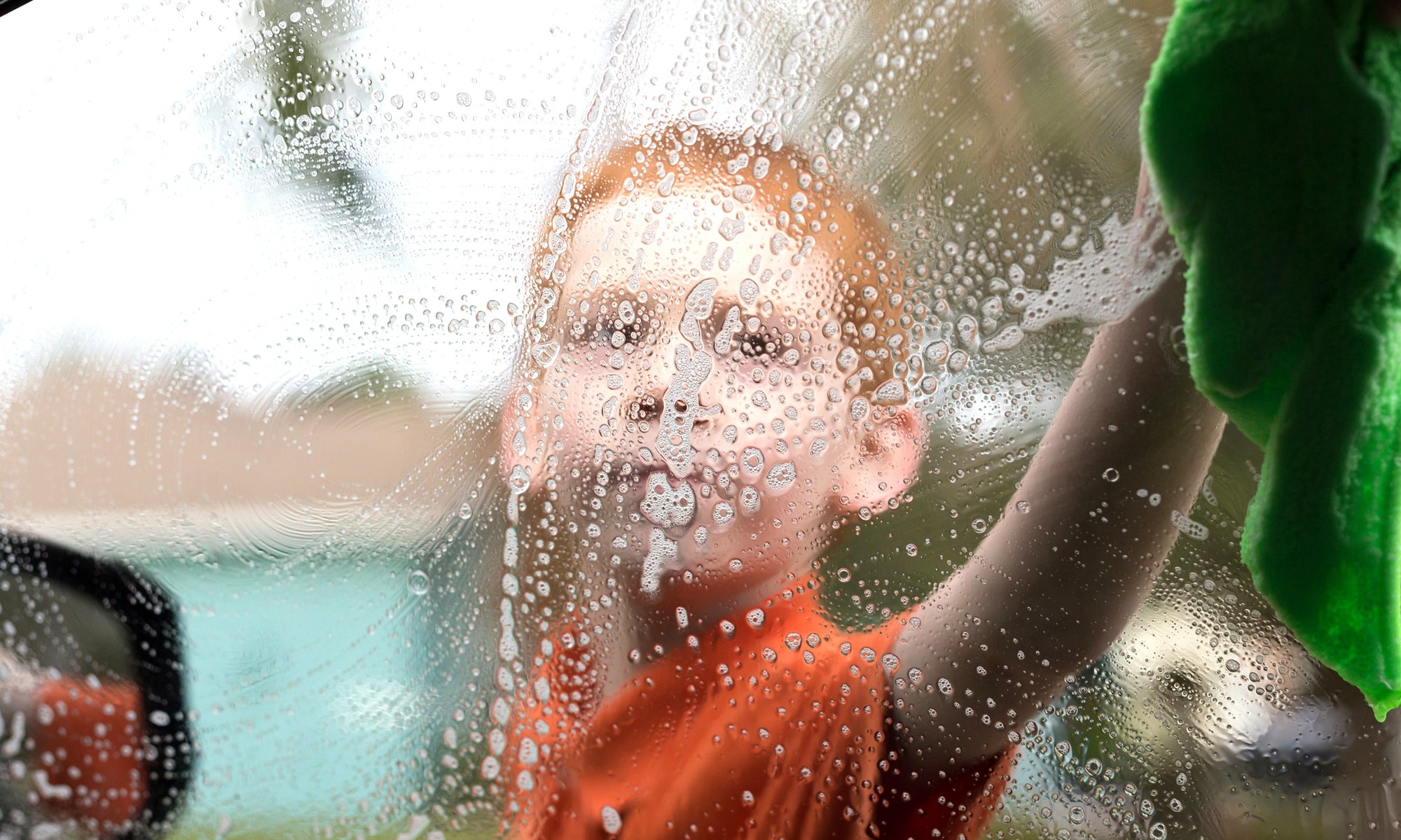 A child washing a car's window