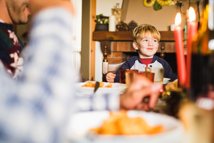 A child sitting in a table along with candles