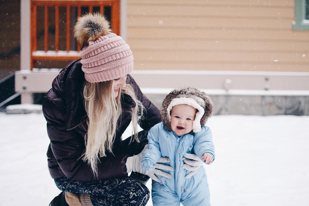 baby and her mother in winter clothes in snow