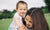 A kid playing with mother in a field