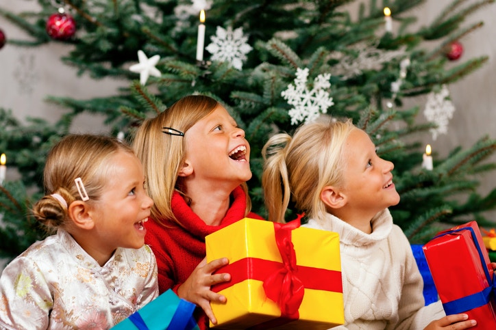 Three young happy girls with Christmas gifts