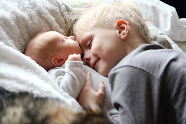 little brother hugging his new born sister