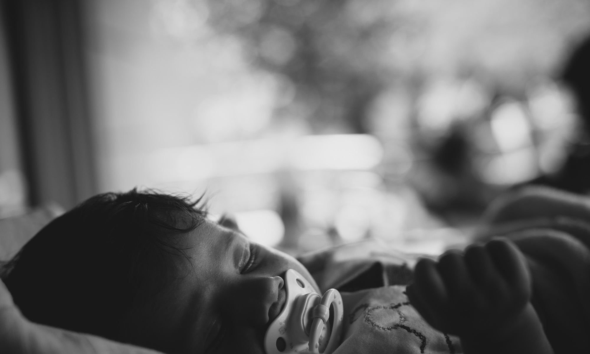 little newborn baby boy with pacifier sleeping