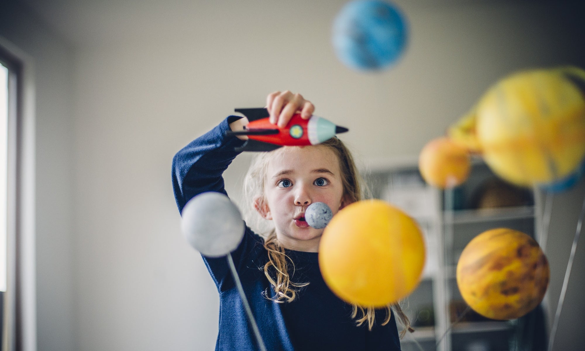 girl playing with space shuttle and planets