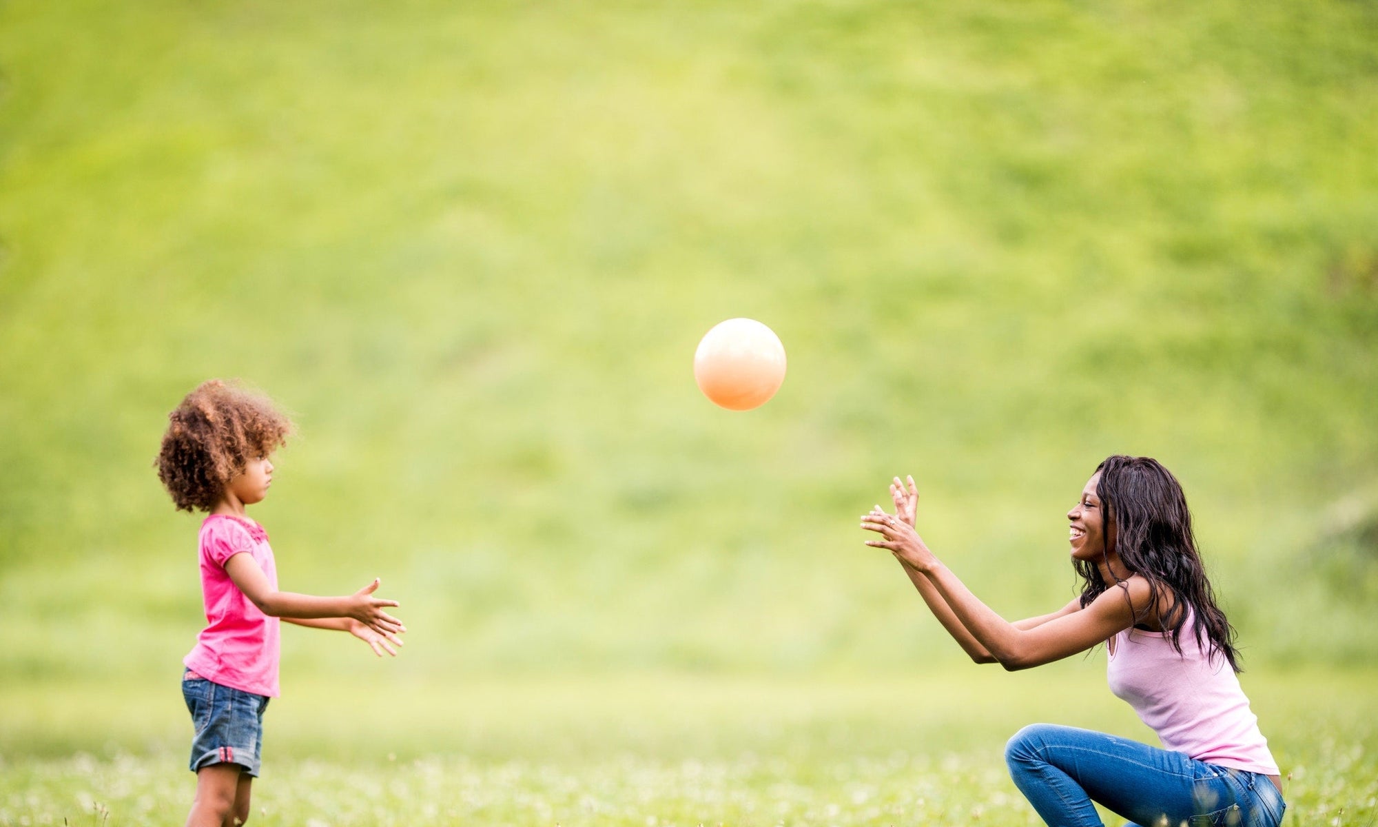 Mother And Daughter Playing In The Meadow