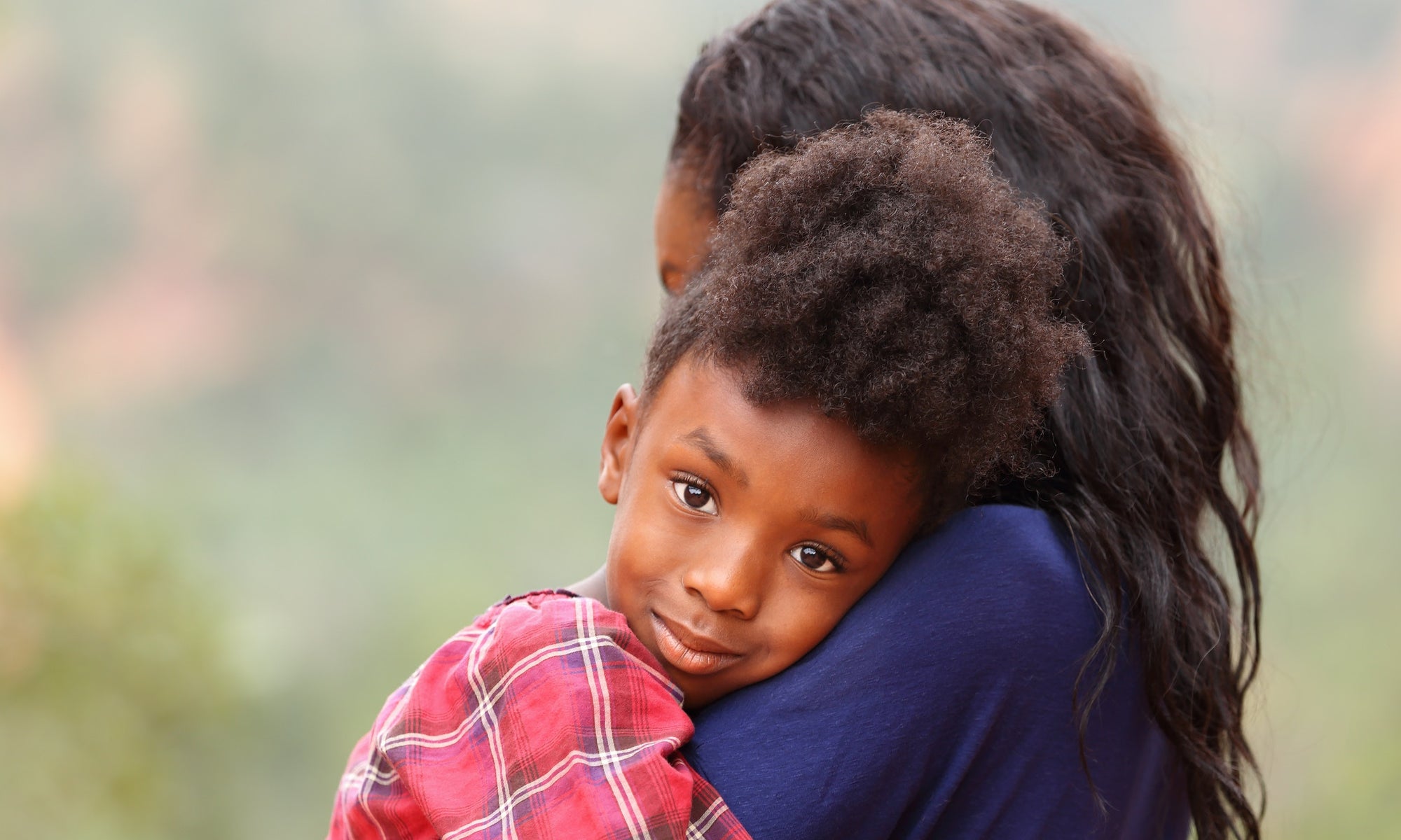 mother holding young kid resting on shoulder