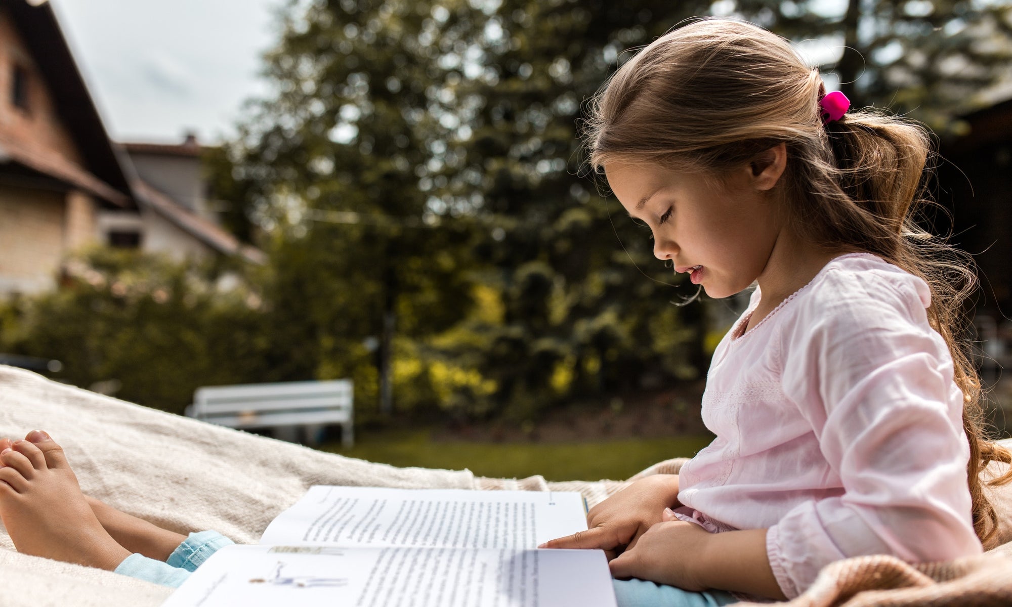 little girl studying outdoors on a sunny day