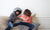 2 boys fighting on a sofa