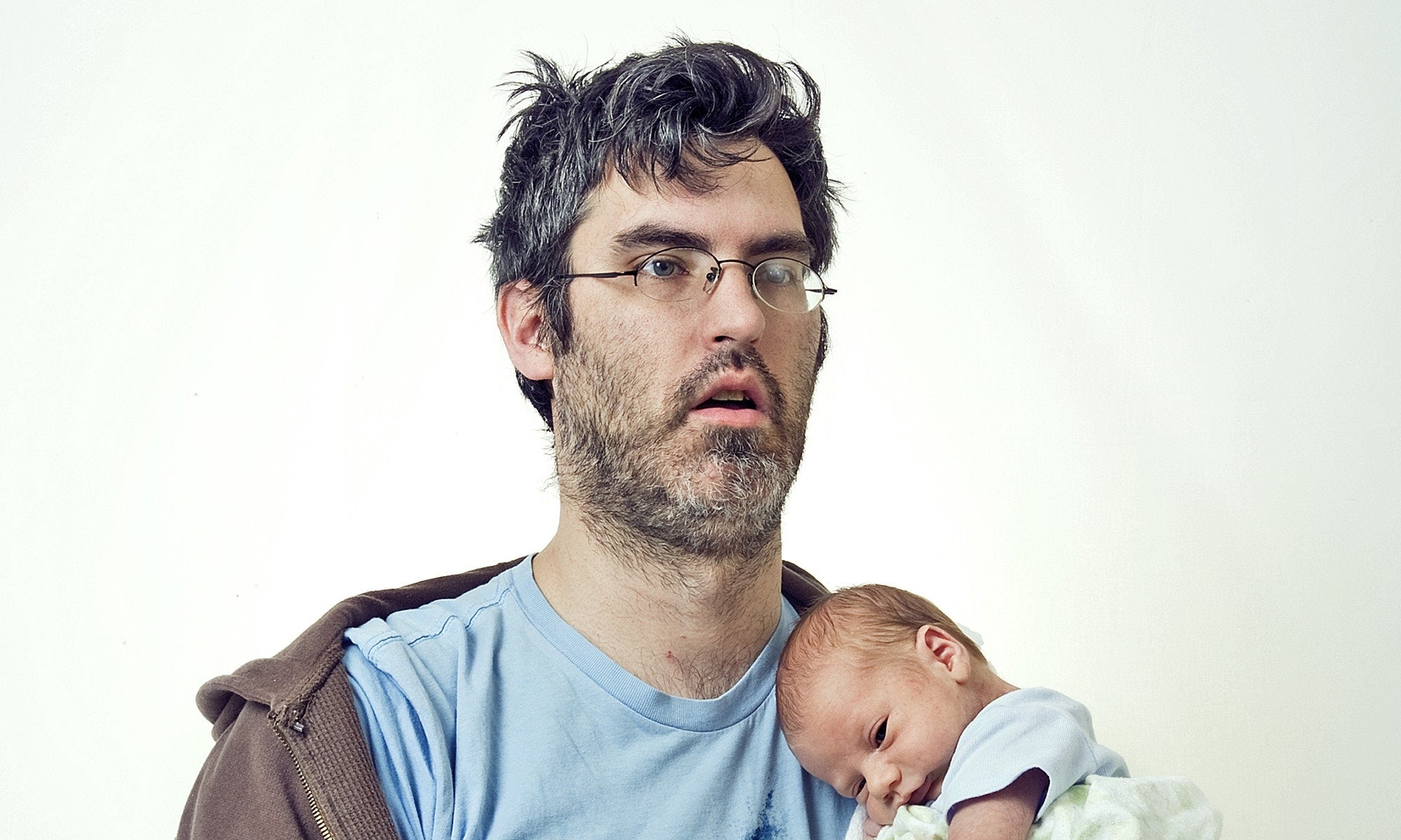 exhausted father holing new born baby