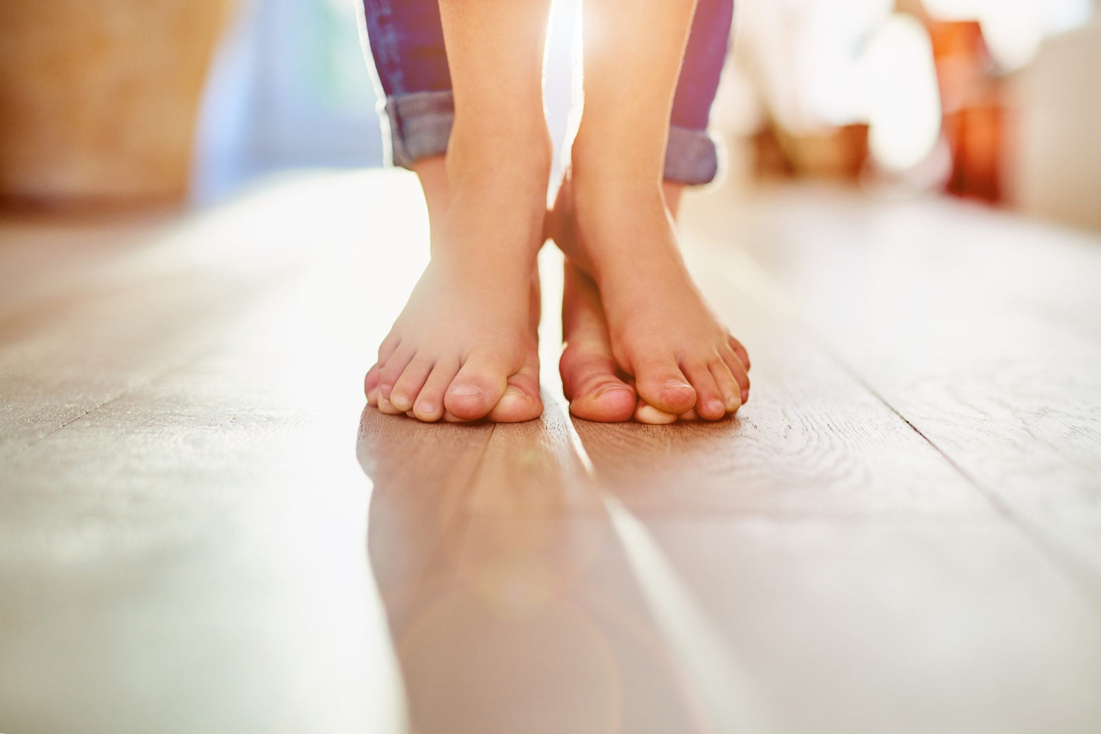 baby standing on mothers feet