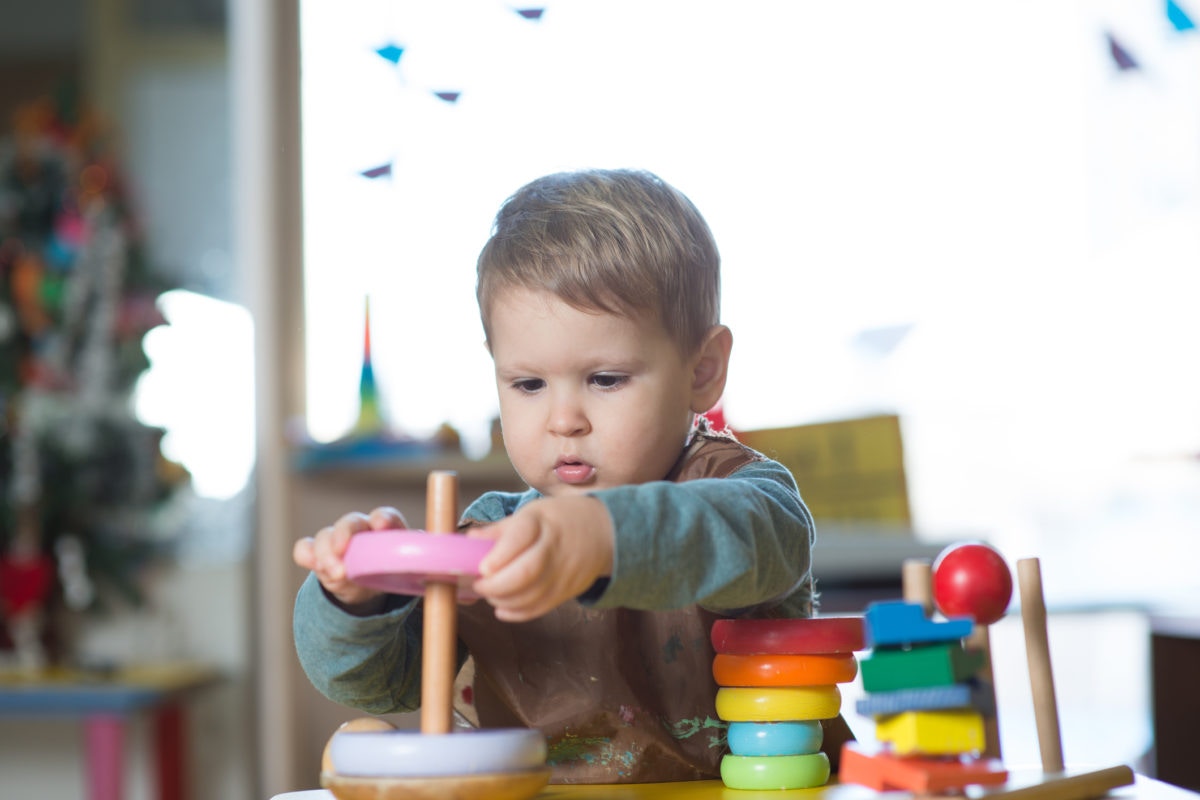 small boy playing with rings toys