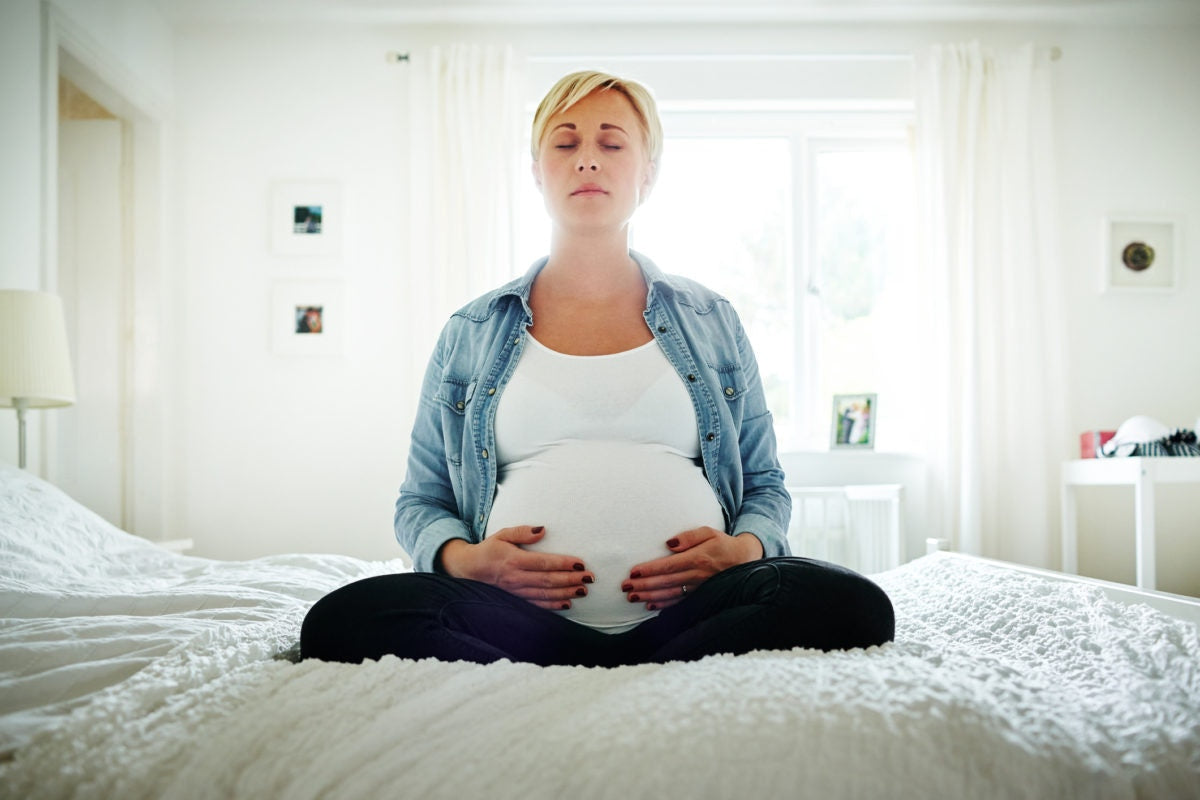 Pregnant lady doing yoga in bed