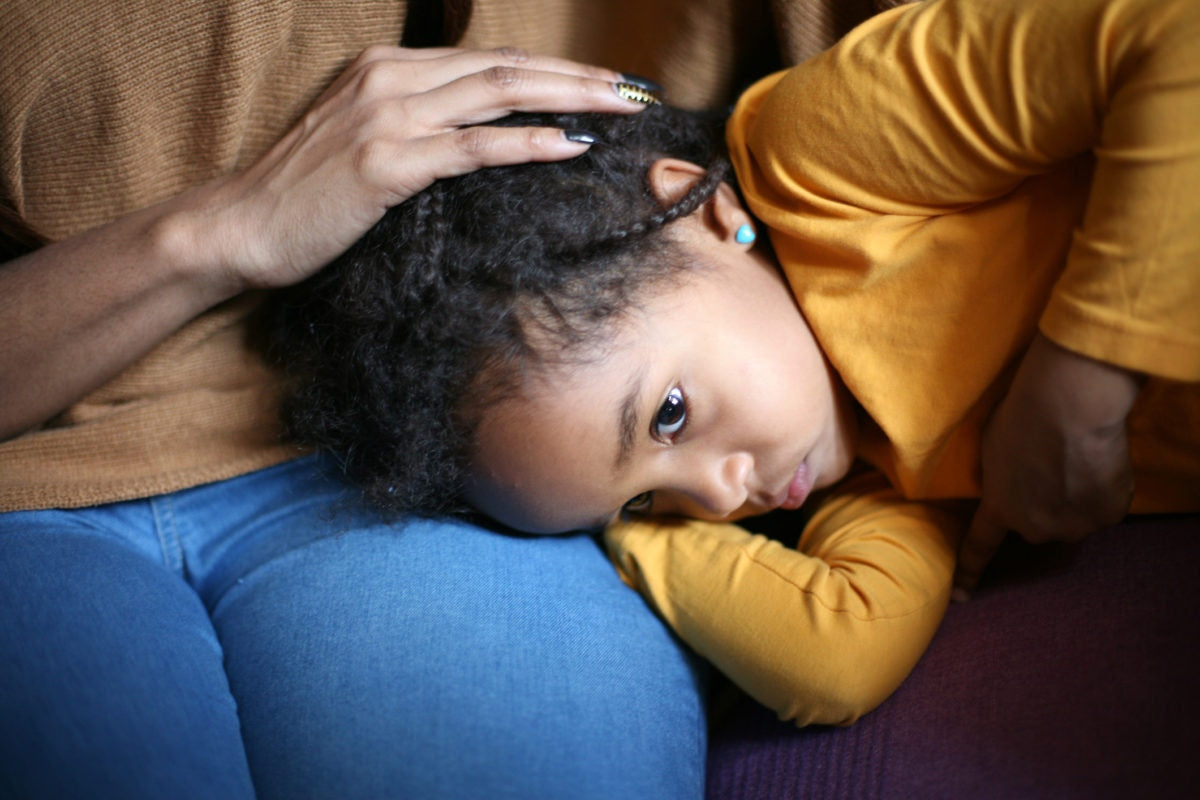 Child head down on mothers lap