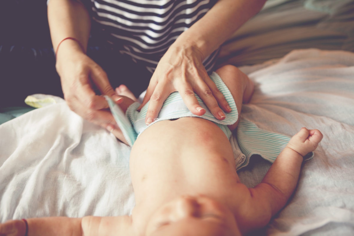 Mom changing diaper for newborn baby