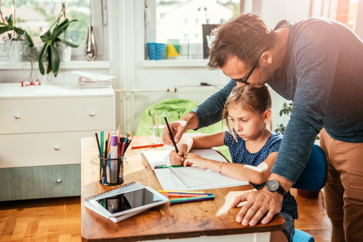 Father is helping to his daughter for doing homework