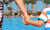 mother holding her child's hand at swimming pool