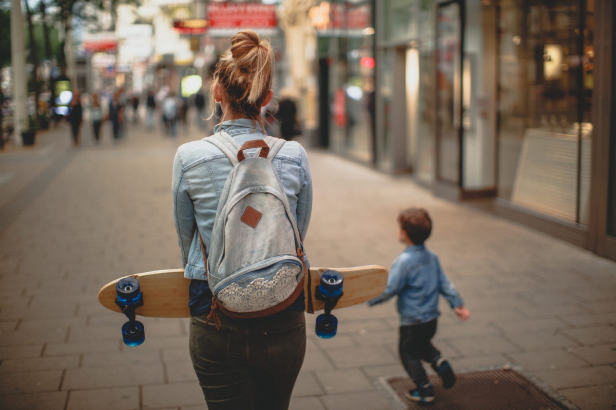 A gilr is standing by holding a skating