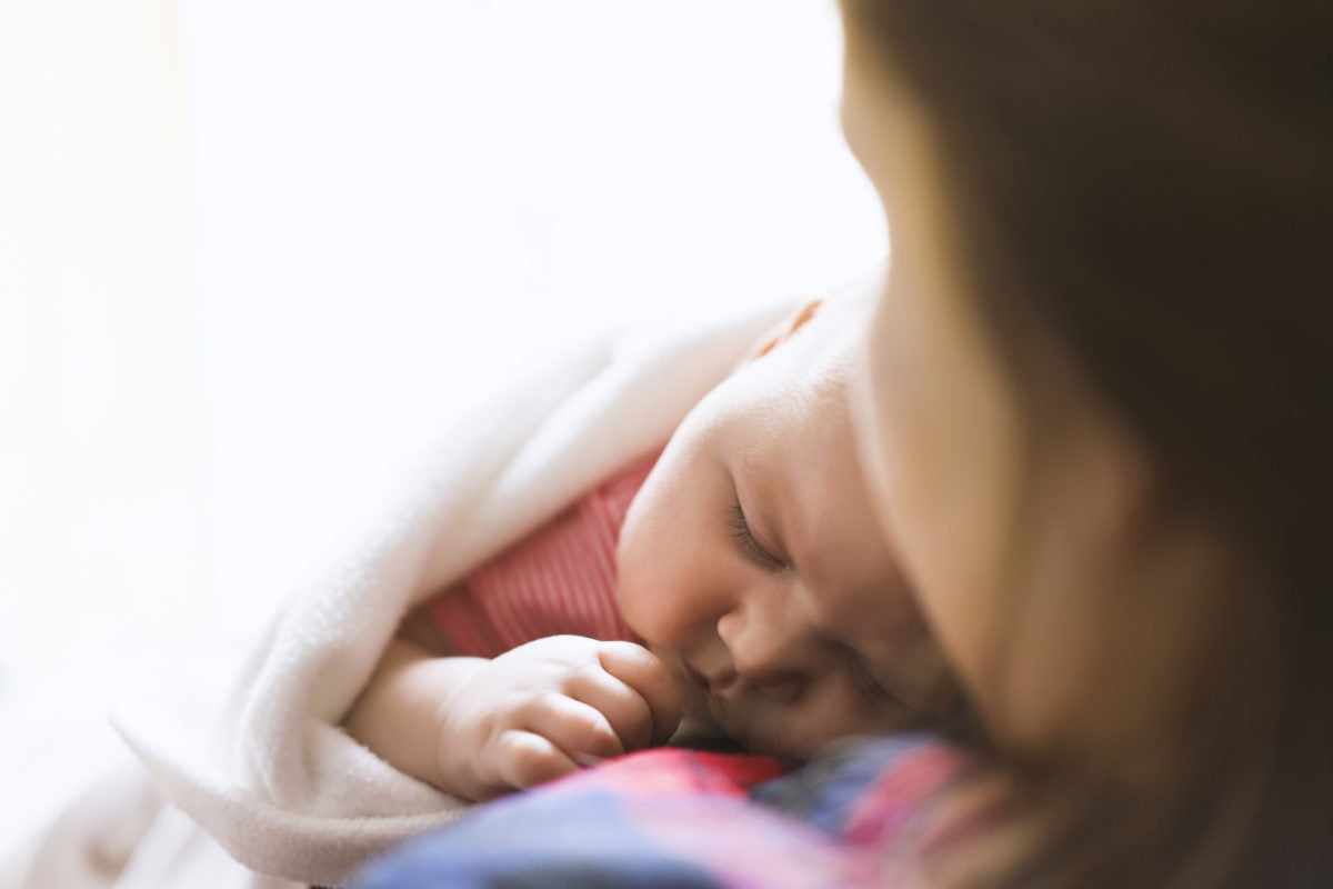 Baby boy sleeping on mothers chest