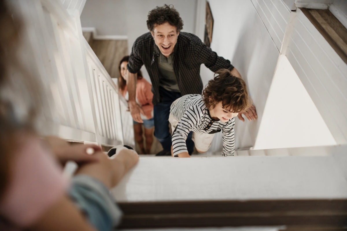 Father helping his little son climbing up the stairs