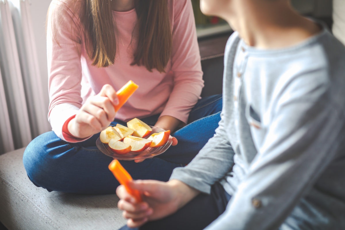 Two friends eating apple