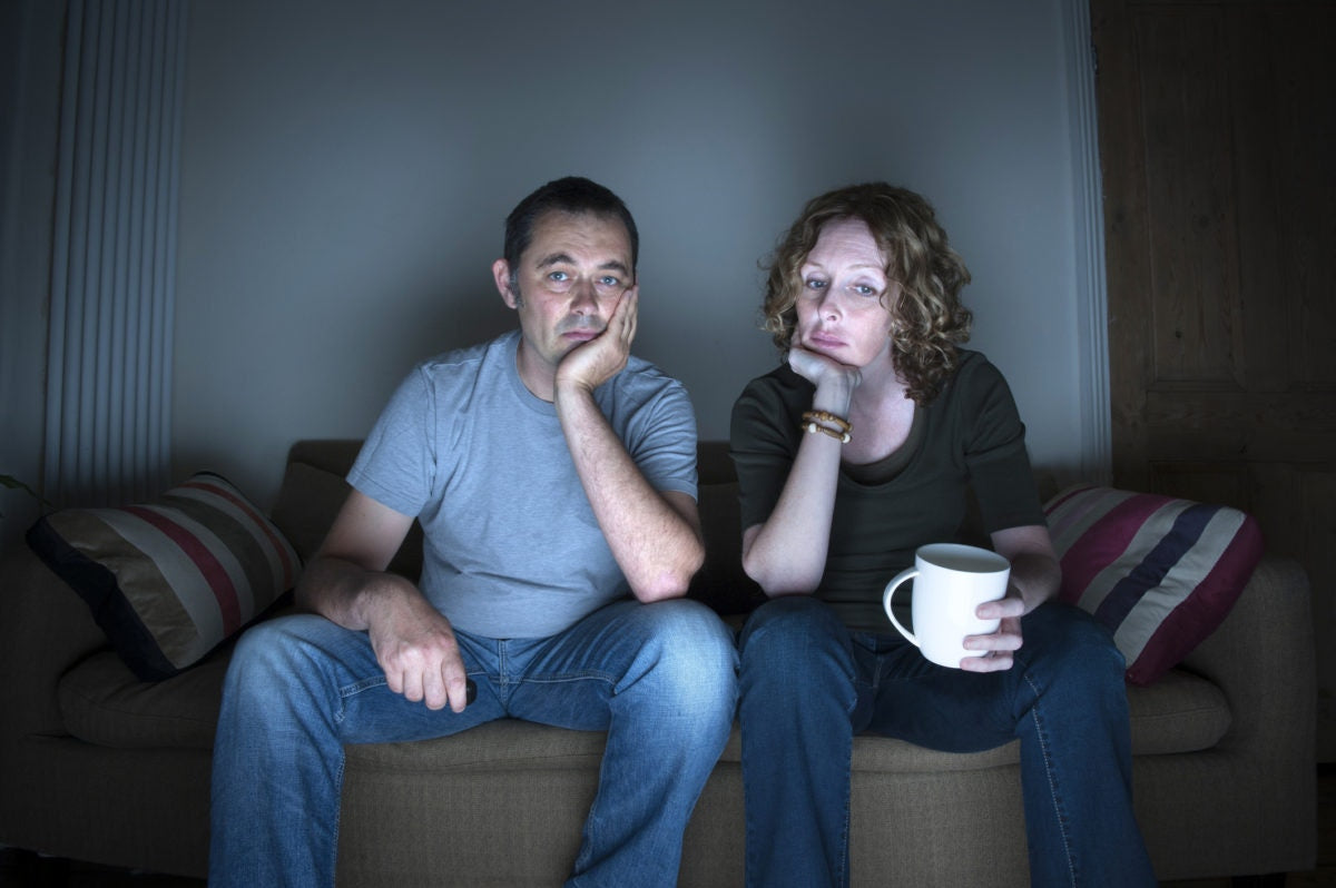 Couples watching TV on a sofa