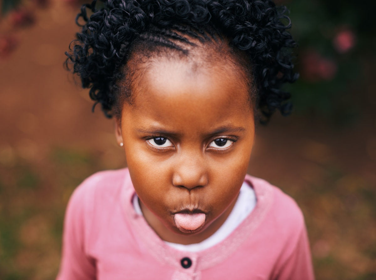 A child giving funny expression by opening tongue