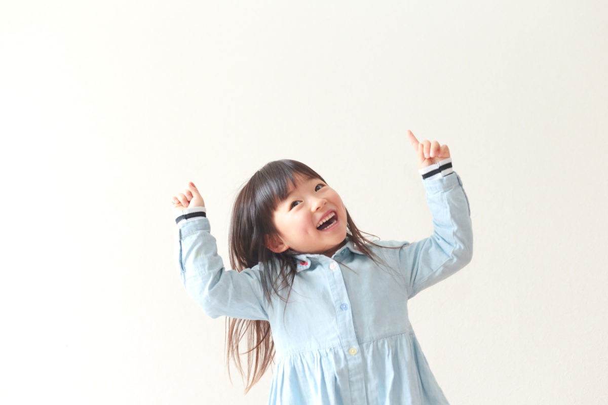 chinese little girl in blue dress with hands up