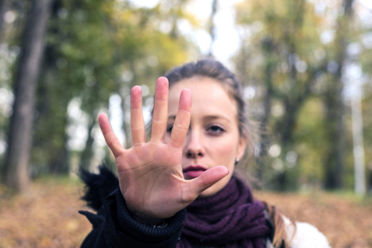 Standing girl showing her palm hand in a straight manner