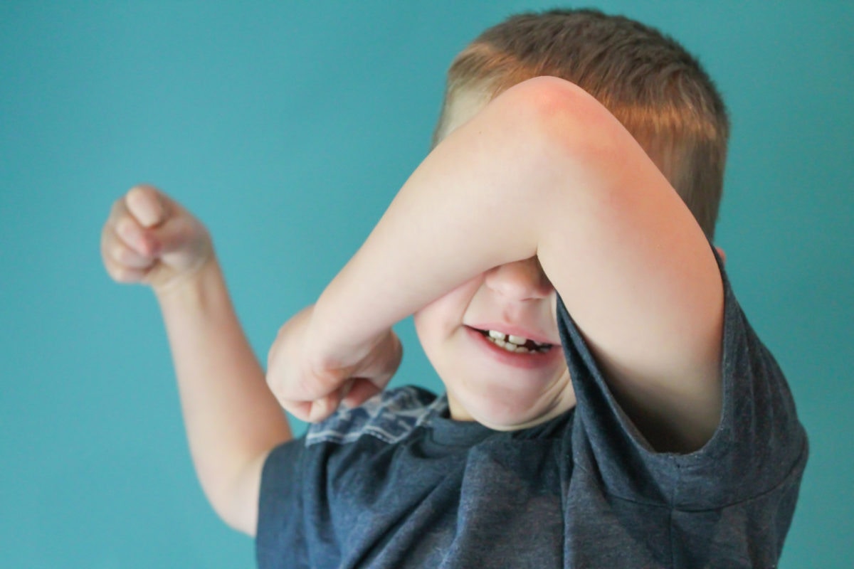 The boy correctly covers his face with his elbow