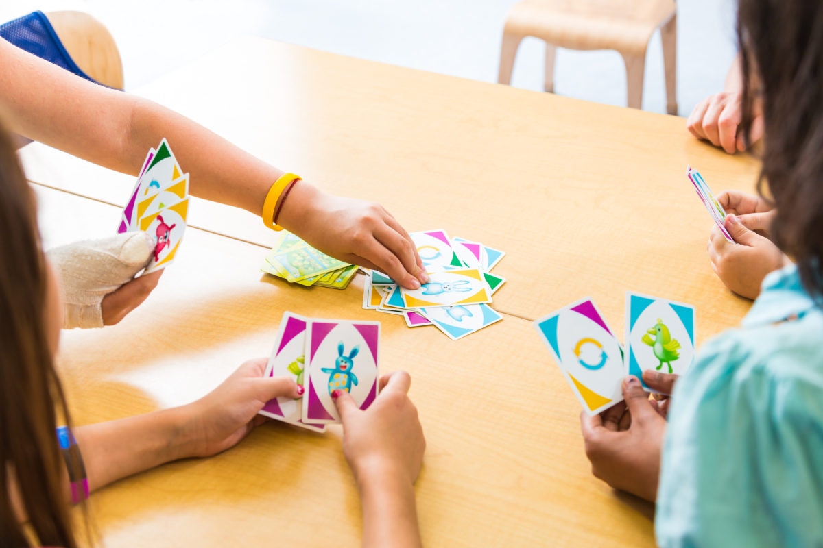 children playing cards at a table