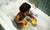 boy playing with rubber duckies in bathtub