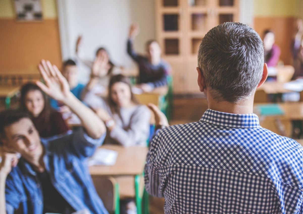 teacher with entire class cheering their hands