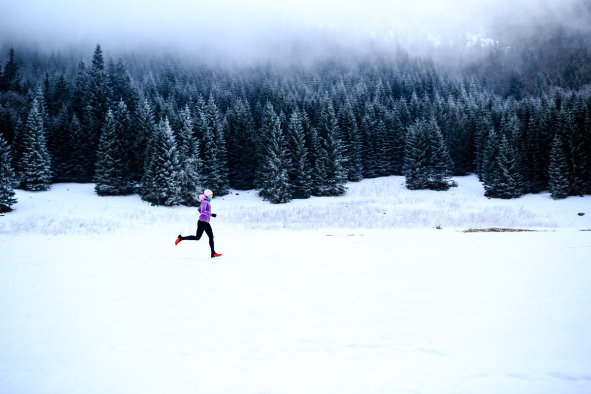 woman running in the snow in the country