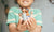 child holding small wooden toy family