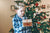 boy looking at a christmas looking not too happy