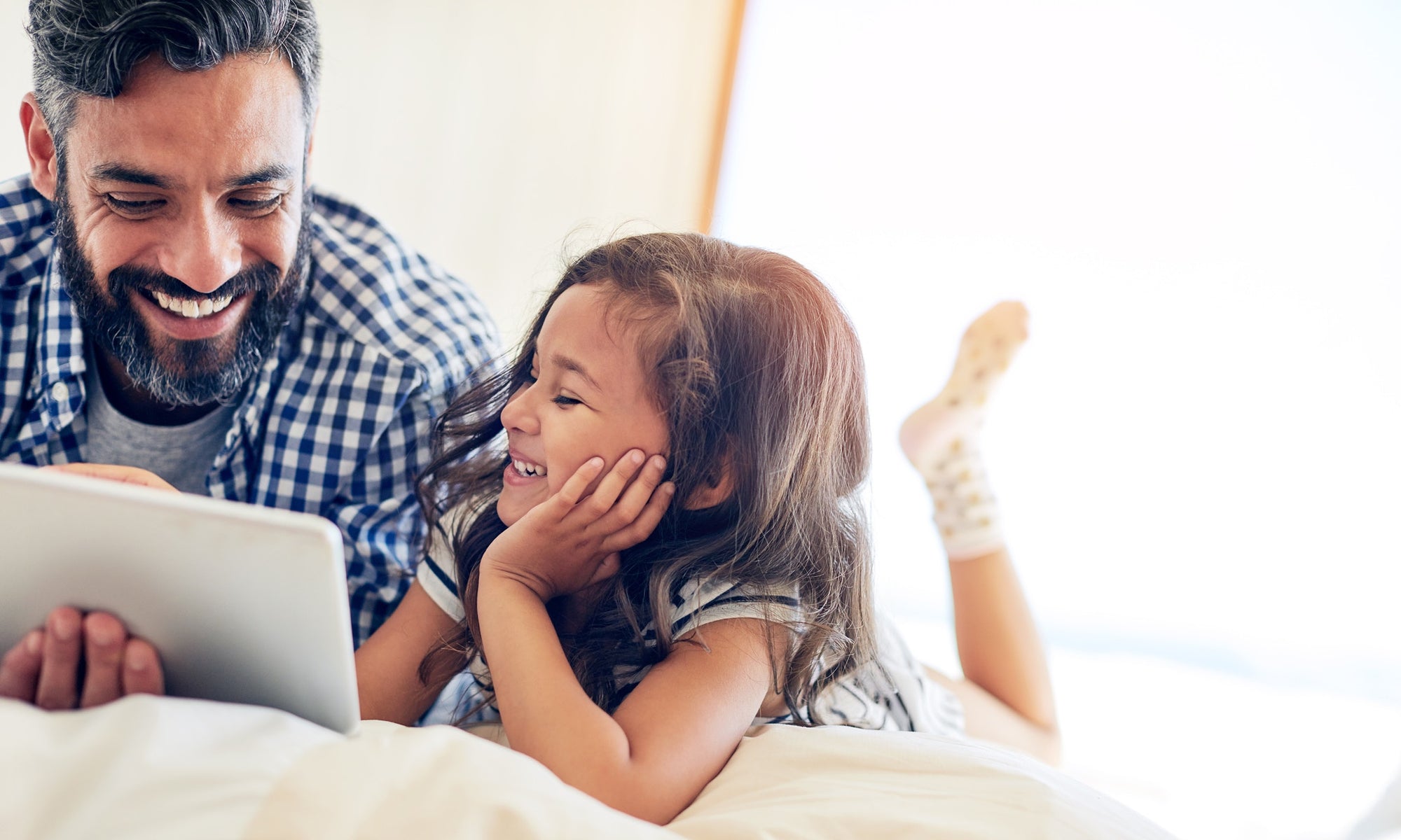 Father watching at tab with his daughter