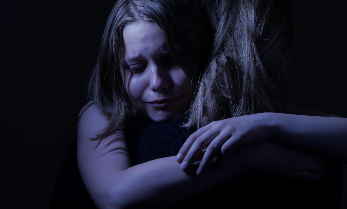 Two girls hugging and crying