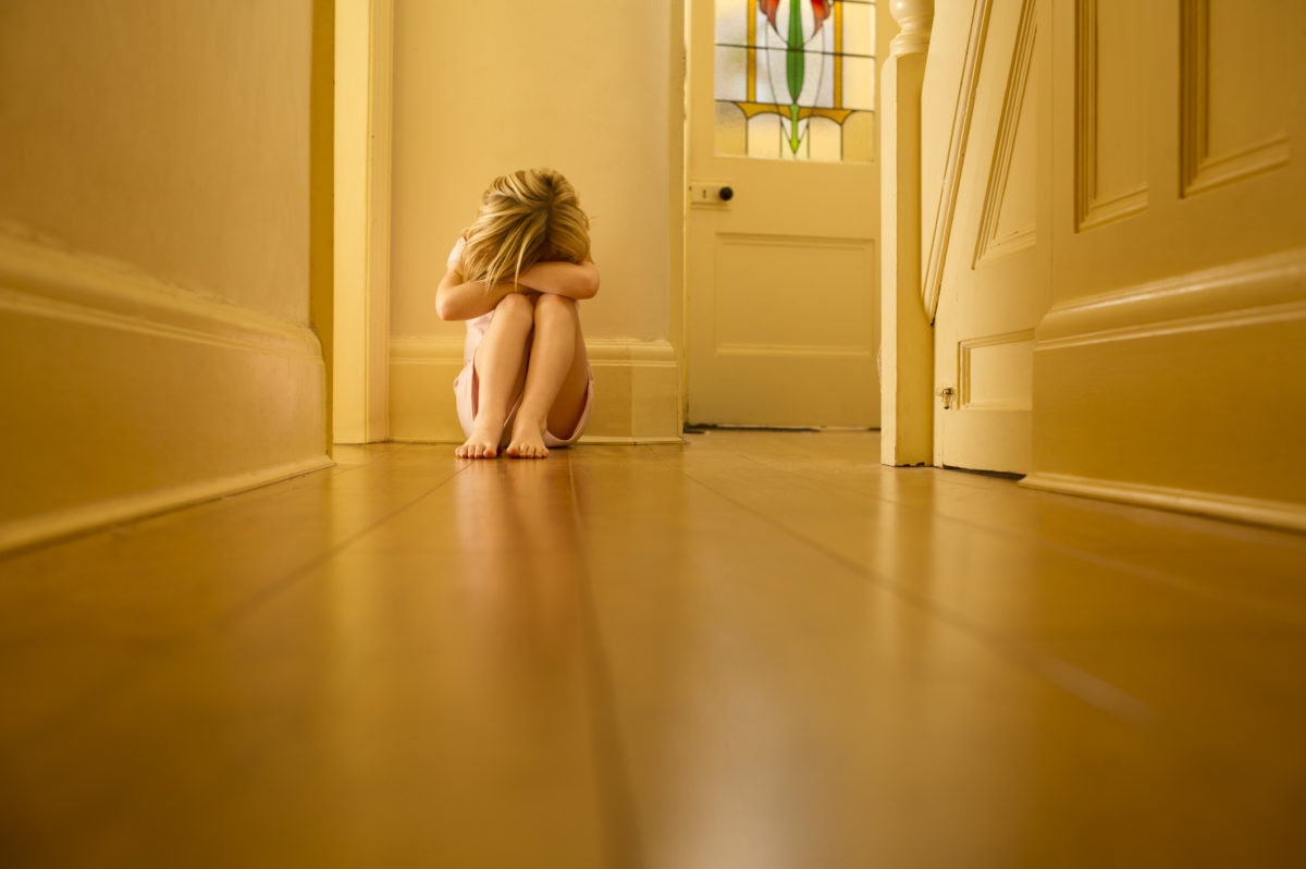 Depressed girl sitting with her head down in home