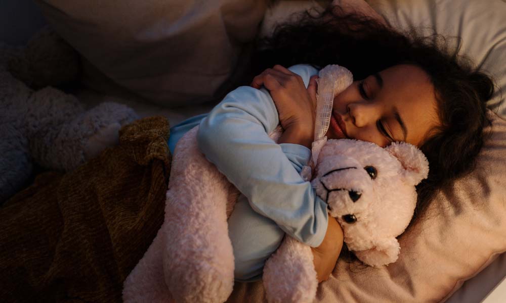 an adorable girl hugging her teddy