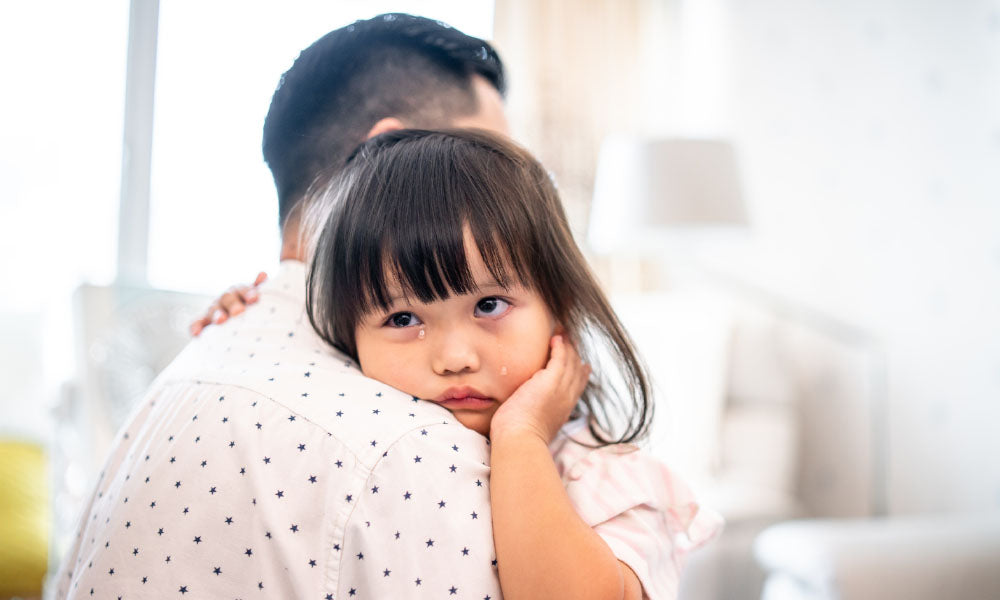 father holding crying child