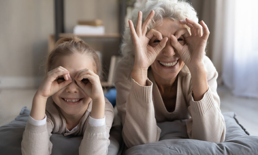 little girl and senior granny show binoculars of fingers